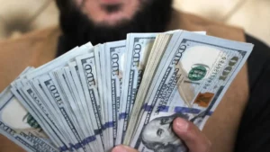 Un homme qui tient des billets de banque (dollar)